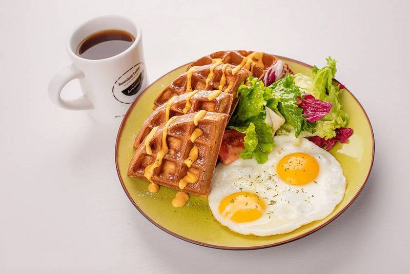 A waffle with a variety of colors, flavors, and flavors paired with a refreshing salad of fried eggs and fruits