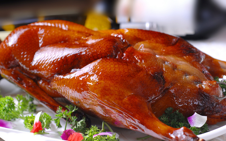 A group of pictures of a whole roasted duck that looks so tempting to eat