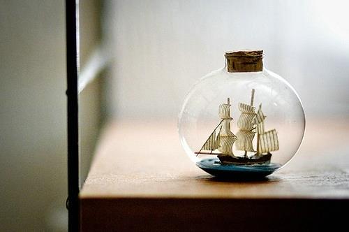 A picture of a sailboat drifting outside in a beautiful bottle