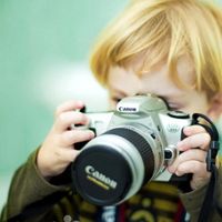 Good-looking boy taking a picture with camera