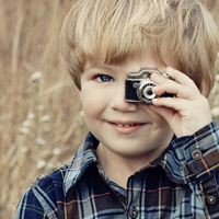 Good-looking boy taking a picture with camera