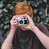 Good-looking boy taking a picture with camera