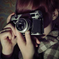 Good-looking boy taking a picture with camera