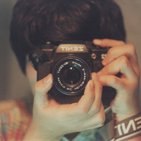 Good-looking boy taking a picture with camera