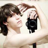 Good-looking boy taking a picture with camera